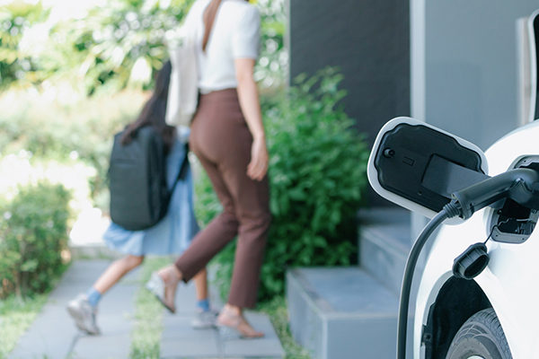Woman charging electric vehicle